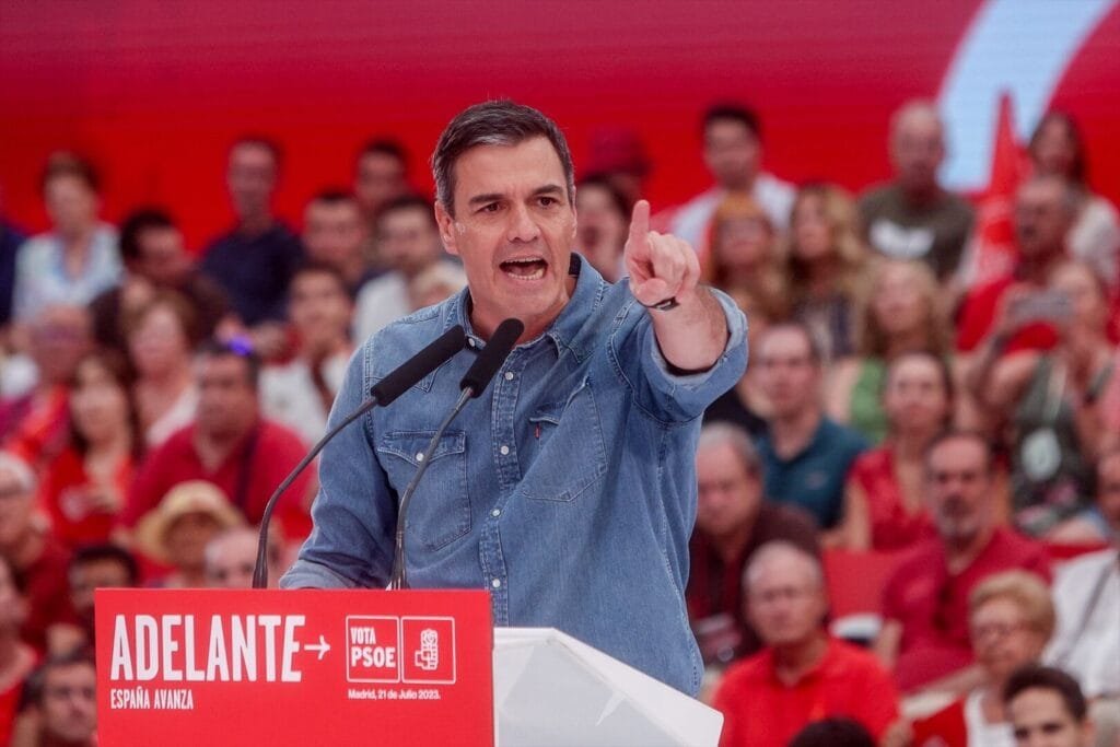 Hombre hablando en un mitin político, fondo rojo.