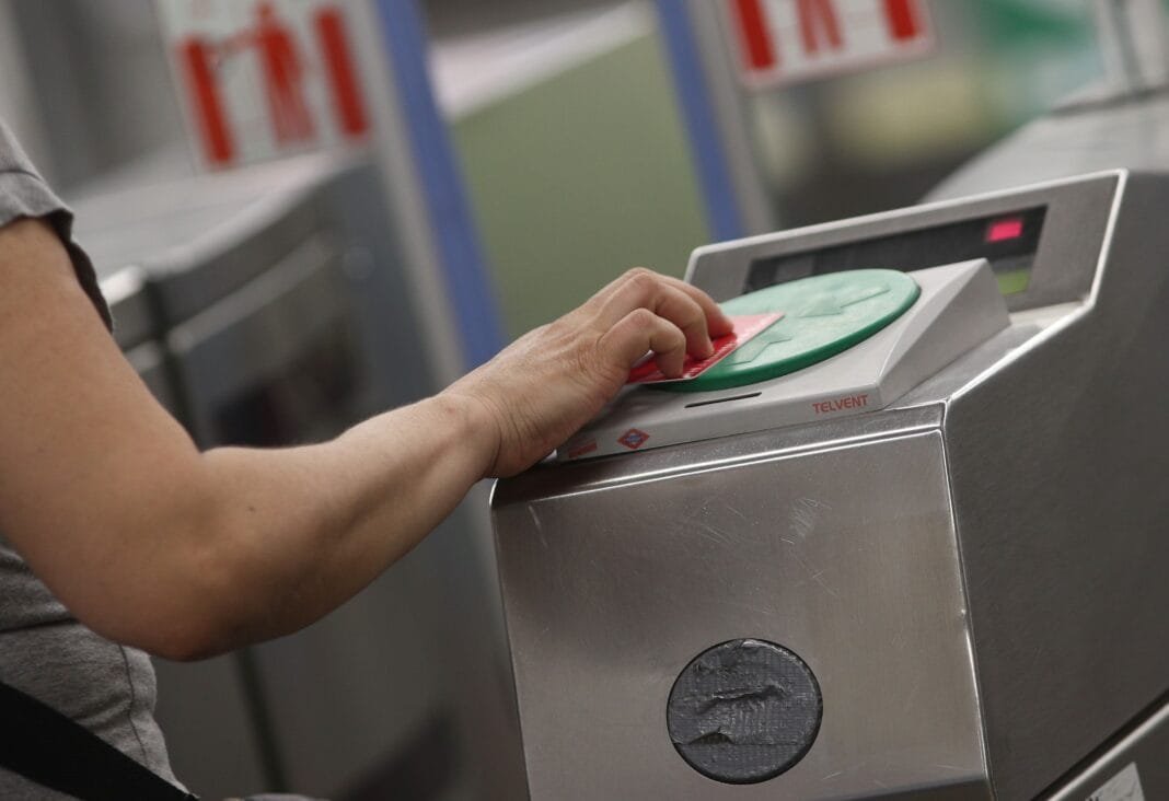 Persona usando tarjeta en torno de metro