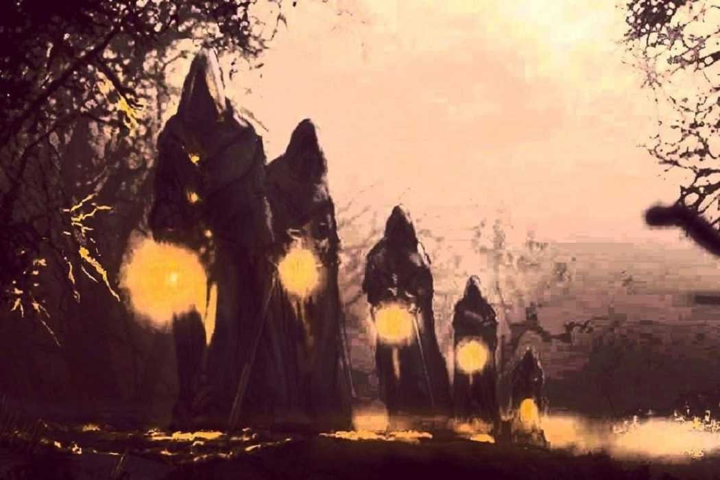 Personas encapuchadas con luces en un bosque oscuro.