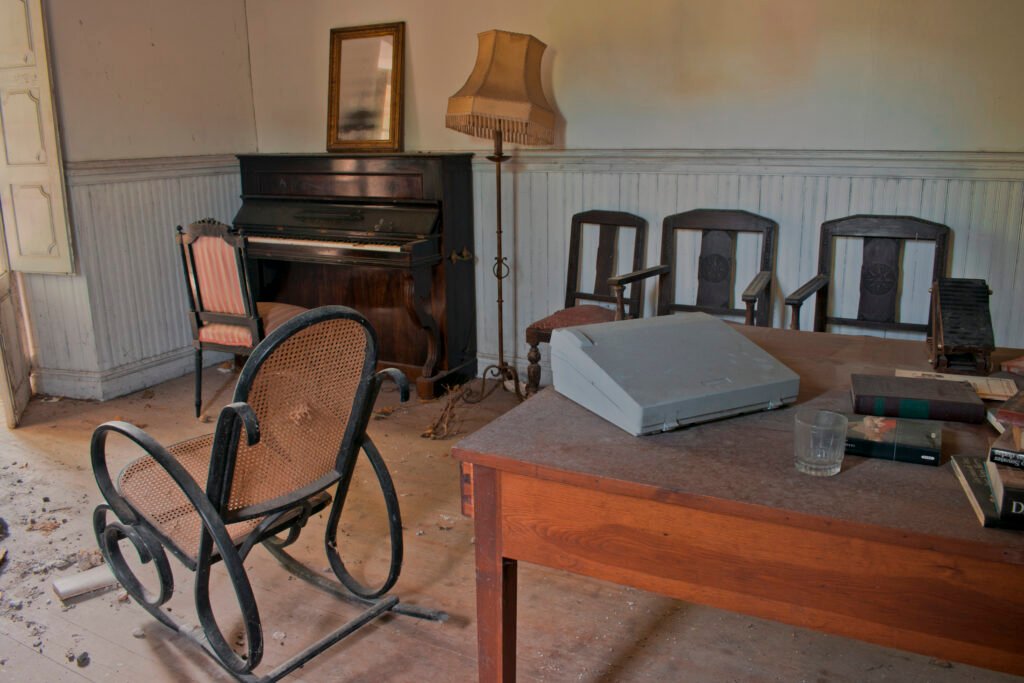 Sala antigua con piano y muebles polvorientos