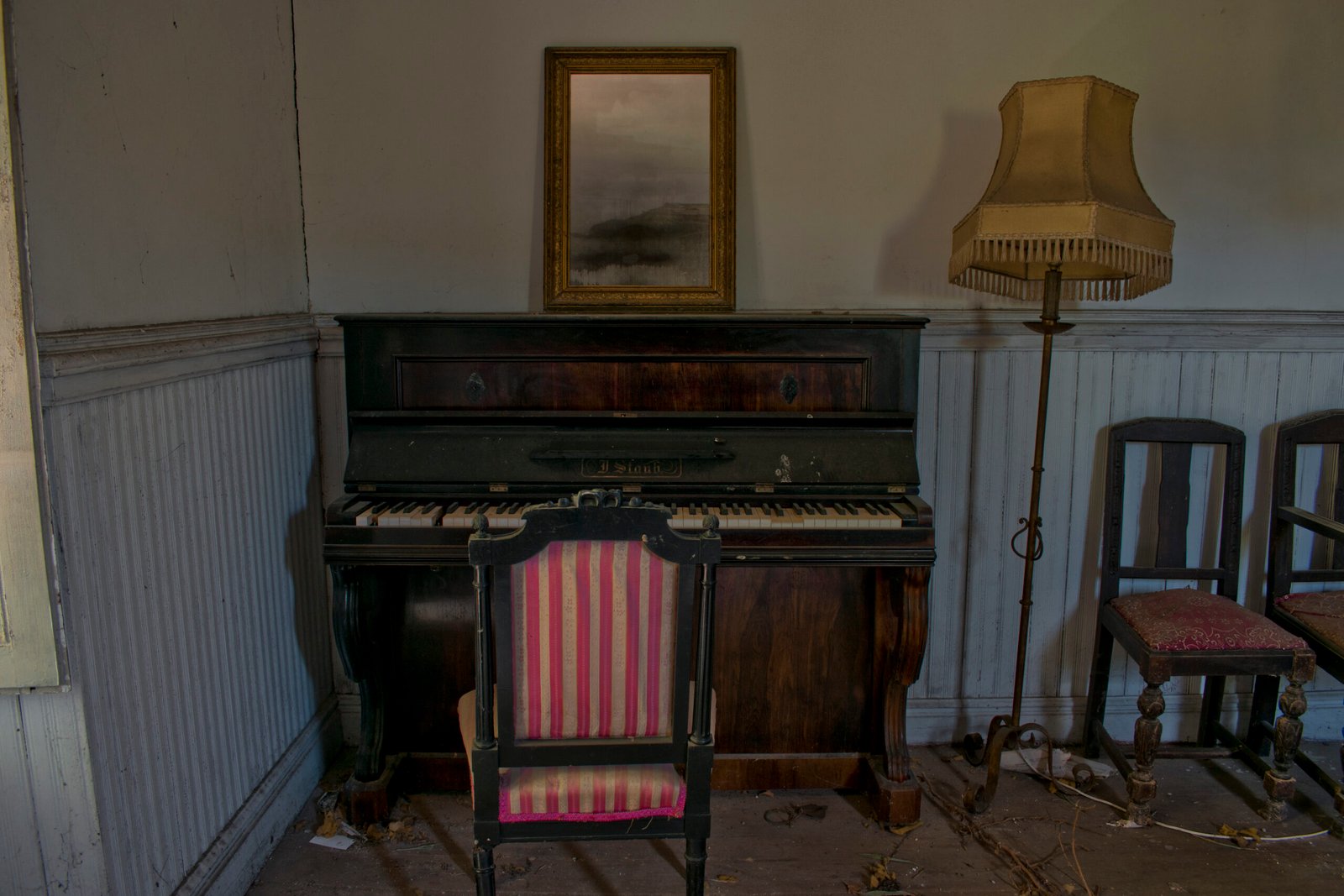 Piano antiguo con sillón y lámpara en sala vintage.