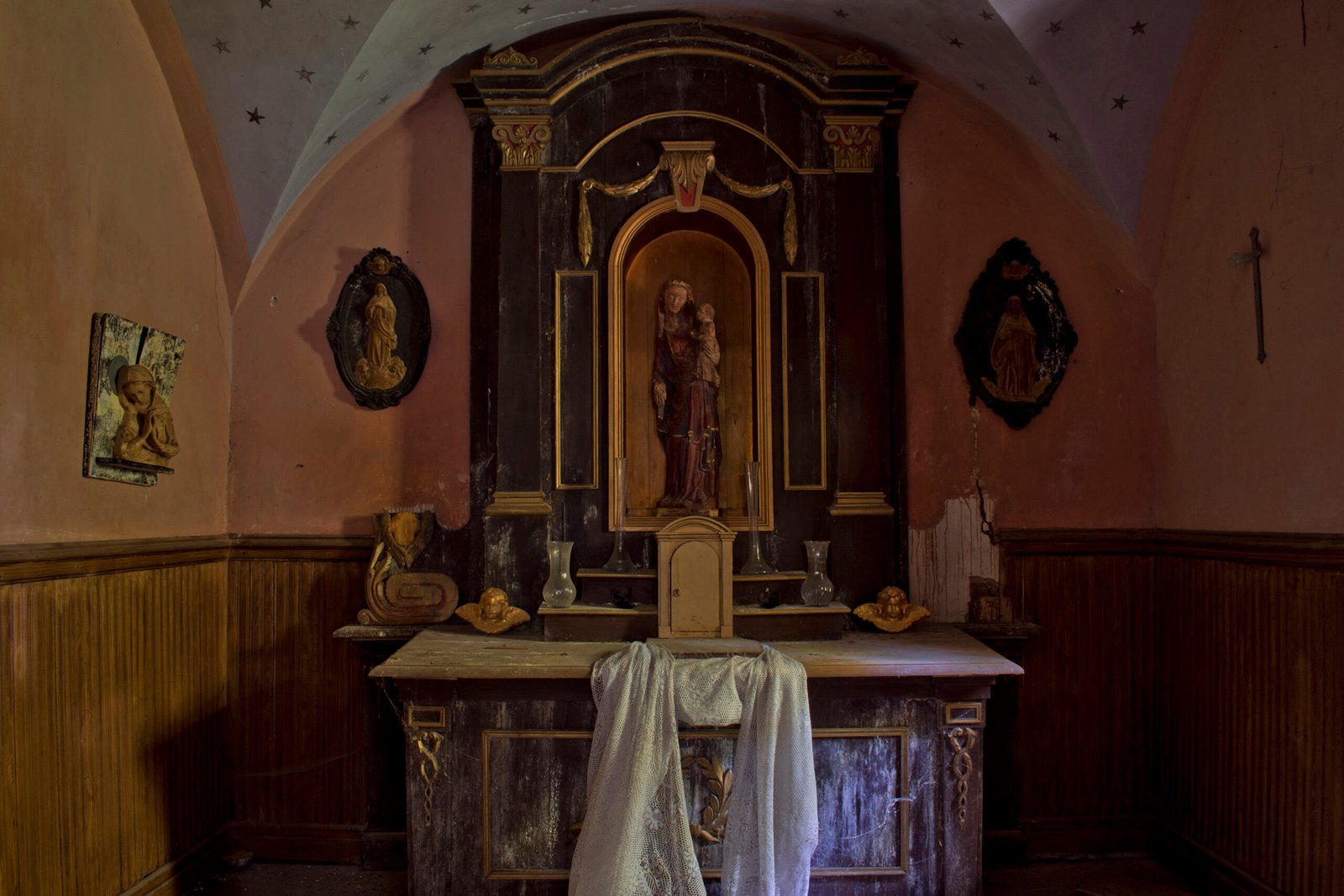 Altar antiguo en capilla pequeña y oscura.