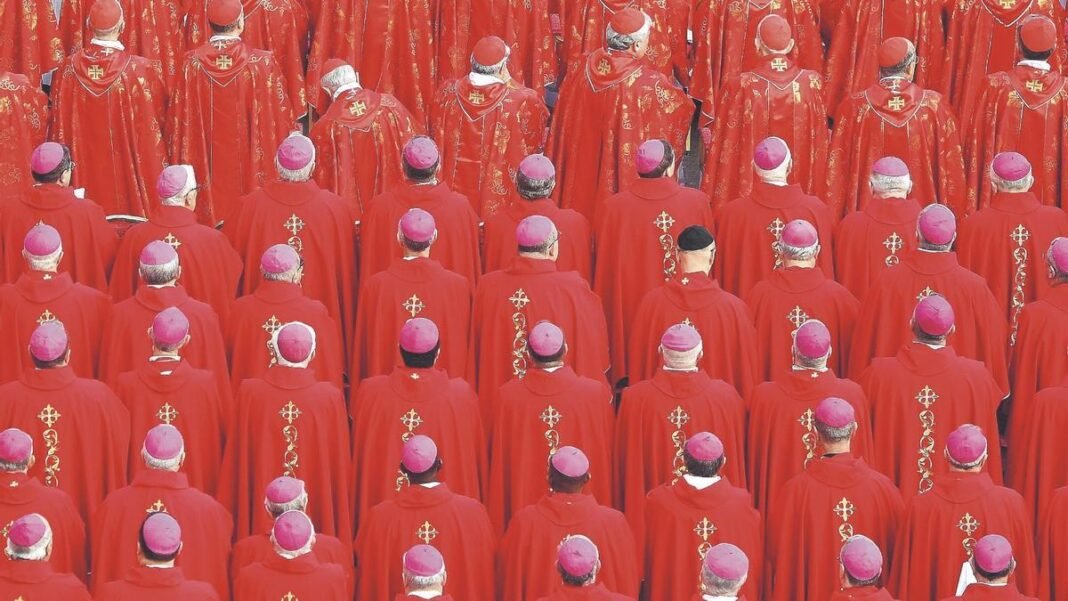 Grupo de personas con vestimenta roja y solideos. Conclave