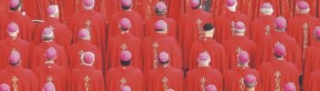 Grupo de personas con vestimenta roja y solideos. Conclave