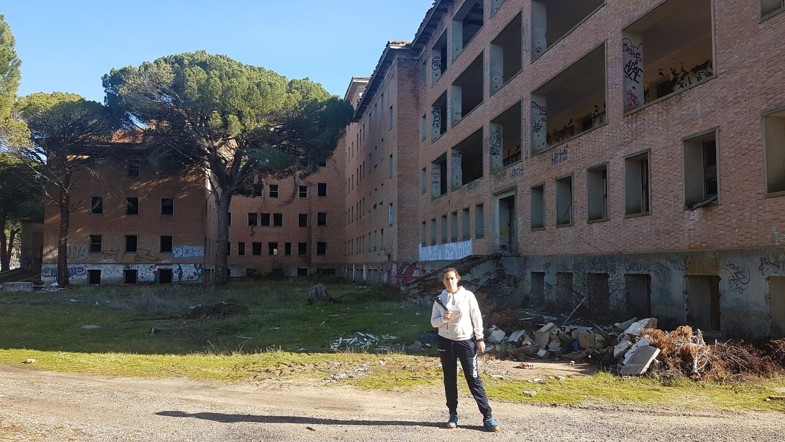 Edificio abandonado graffitis y bosque de pinos