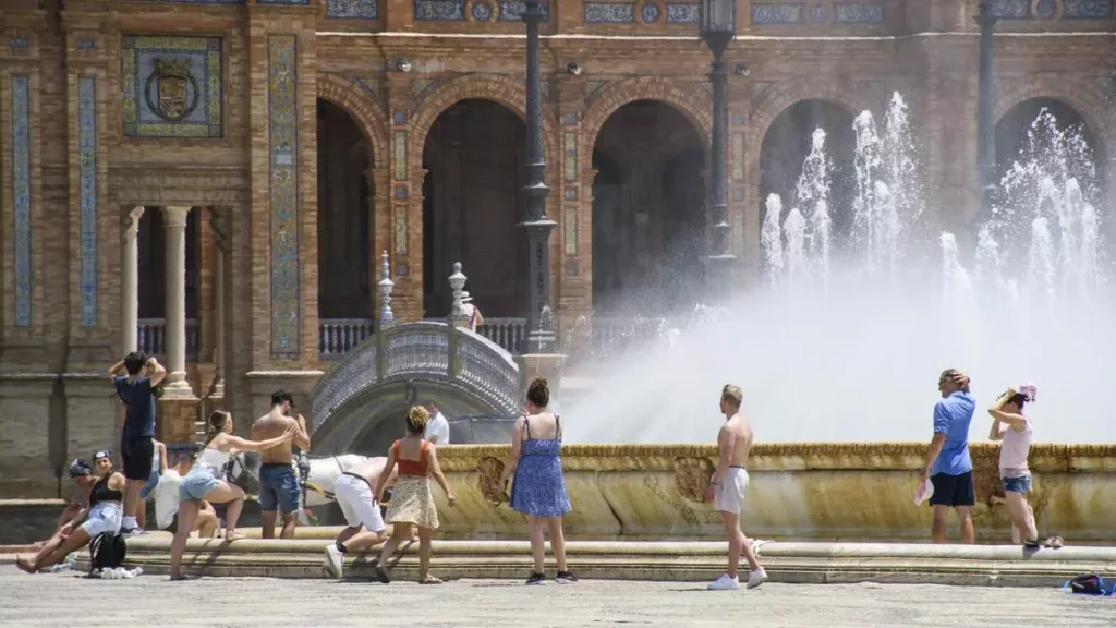 Personas junto a fuente en la Plaza de España.