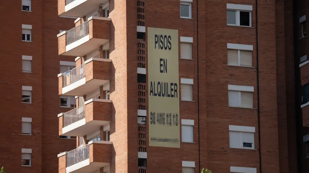 Edificio con letrero de pisos en alquiler