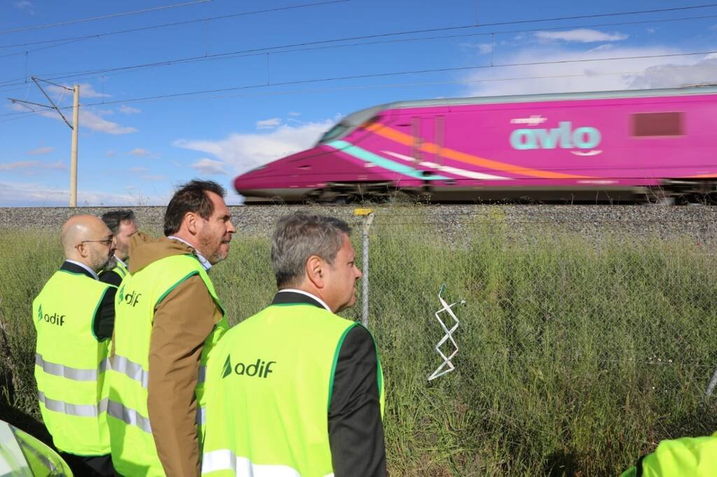 Trabajadores observan tren Avlo en movimiento.