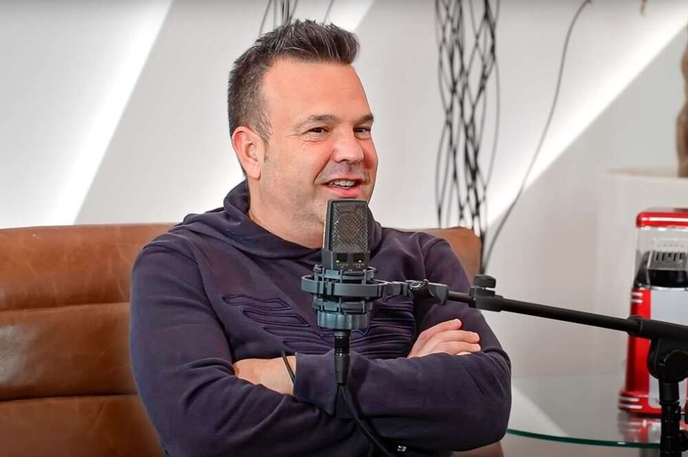 Hombre hablando frente a micrófono en entrevista.