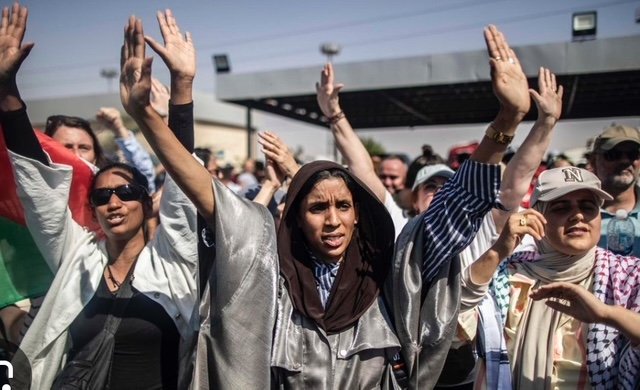 Mujeres levantando manos en una manifestación.
