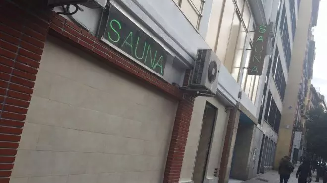 Edificio comercial con letreros de sauna en Madrid.