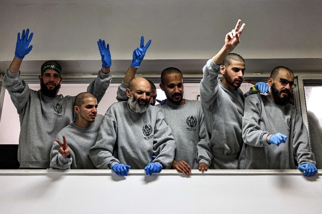 Grupo de personas saludando desde un balcón interior.