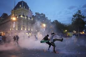 Protesta con humo en ciudad al anochecer